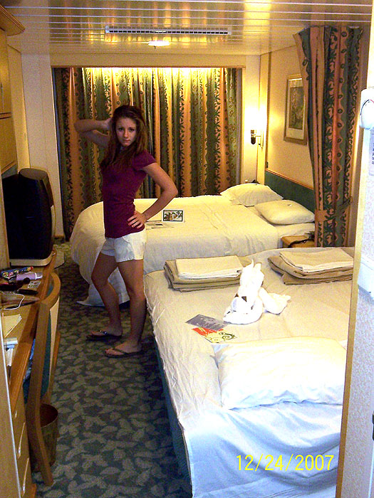Kelly striking a pose with the stateroom attendant's towel animal looking on.