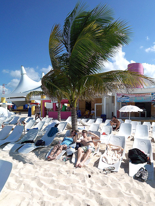 Anna and Ben on the beach at Playa Mia Resort, Cozumel, Mexico, soaking up the sun.