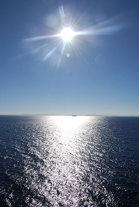 A cruise ship siloetted in front of the mountainous coast of Belize - Ben Kitzmiller