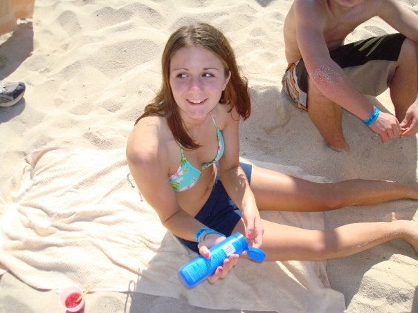 Kelly pretending to apply sun block while secretly working on her tan.